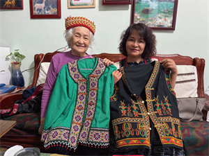 Hudas Abi與莎妃拿著Hudas Abi所做的衣服合照。照片來源：嶼典創社顧問有限公司提供