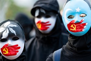  A group of protestors wear masks symbolizing the Communist Party of China's silencing of Uyghur Mus