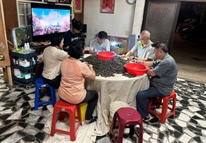 家族成員圍繞圓桌撿茶